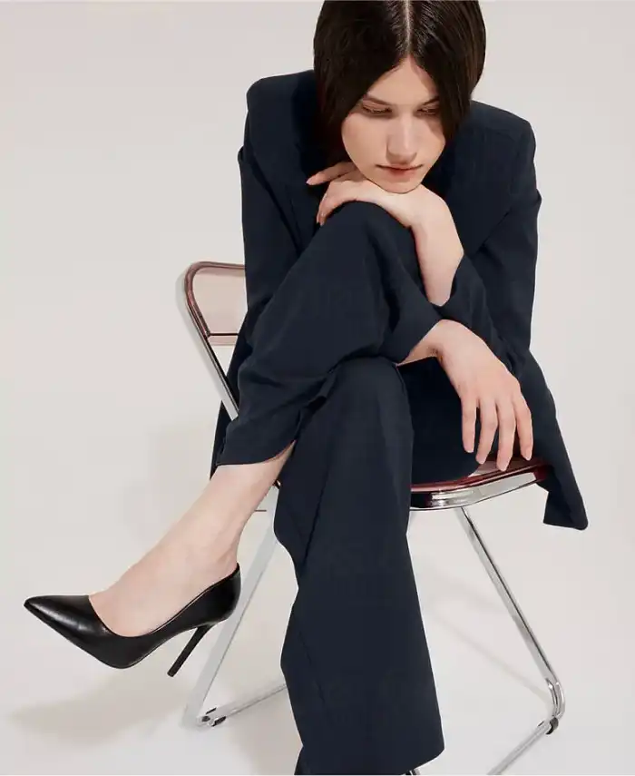 Lady in elegant suit sitting with legs crossed