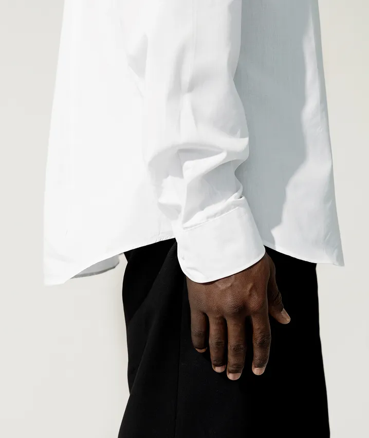 Side view of a dark skinned man wearing a crisp white shirt